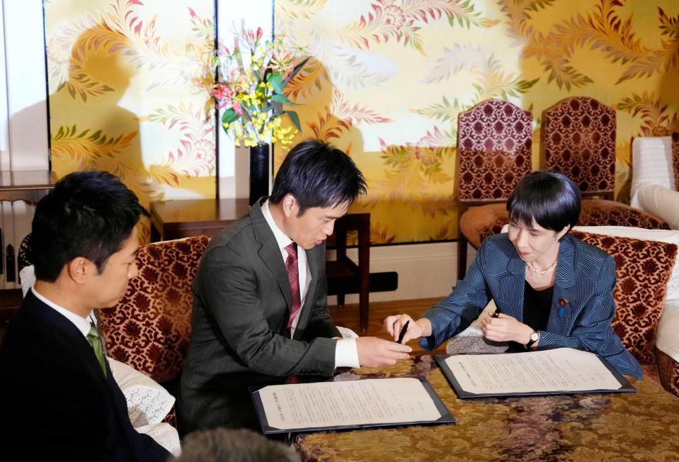 　１本の万年筆で連立政権合意書に署名する自民党の高市総裁（右）と日本維新の会の吉村代表（中央）＝１０月２０日