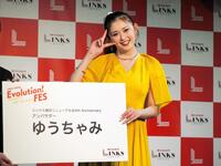 　「リンクス梅田」公式アンバサダー就任式で、特大名刺を手に笑顔を見せるゆうちゃみ