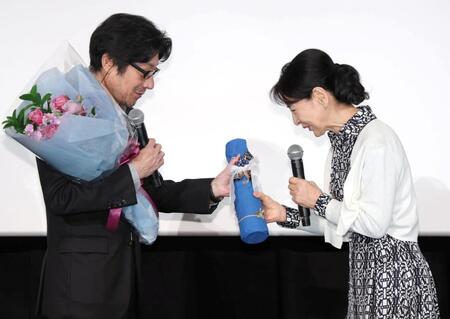 紫綬褒章を受章した阪本順治監督（左）に自宅から持ってきたワインを贈る吉永小百合＝ＴＯＨＯシネマズ日本橋（撮影・吉澤敬太） 