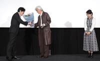 　紫綬褒章を受章した阪本順治監督（左）に花束を贈る佐藤浩市（中央）。右は吉永小百合（撮影・吉澤敬太）