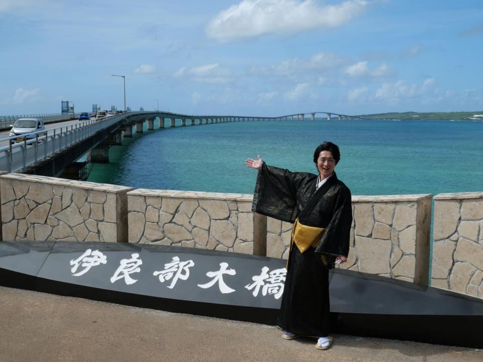 　伊良部大橋前で笑顔を浮かべる真田ナオキ