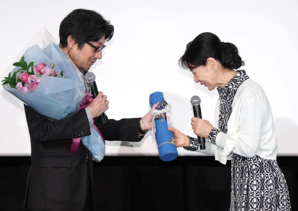 紫綬褒章を受章した阪本順治監督（左）に自宅から持ってきたワインを贈る吉永小百合＝ＴＯＨＯシネマズ日本橋（撮影・吉澤敬太） 