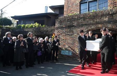 　ひつぎに手を合わせる役所広司（左端）ら参列者（撮影・石井剣太郎）