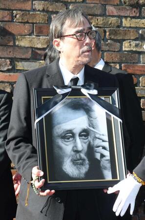 　遺影を手にする益岡徹（撮影・石井剣太郎）