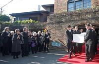 　ひつぎに手を合わせる役所広司（左端）ら参列者（撮影・石井剣太郎）