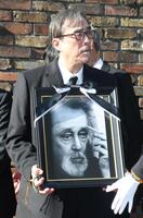 　遺影を手にする益岡徹（撮影・石井剣太郎）