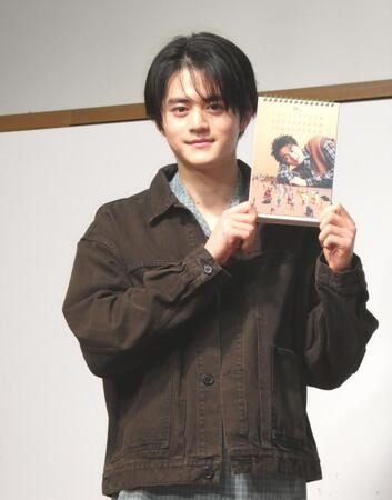 　カレンダーのお気に入りの「９月」のページを見せる鈴鹿央士