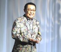 　トロフィーを手に笑顔を見せるさだまさし