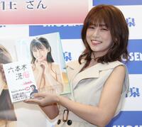 　本と写真集を手にする小阪由佳（撮影・西岡正）