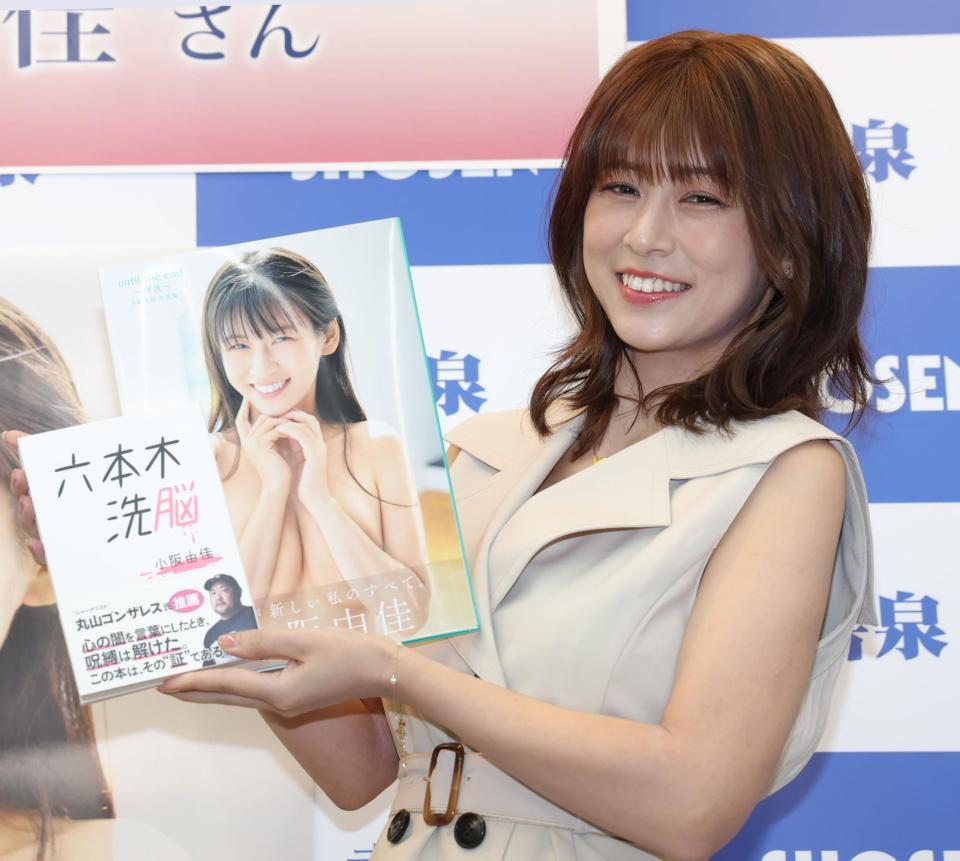 　本と写真集を手にする小阪由佳（撮影・西岡正）