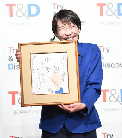 　選考委員のやくみつるから贈呈されたイラスト入り色紙を手に感激の高市早苗首相（撮影・開出牧）