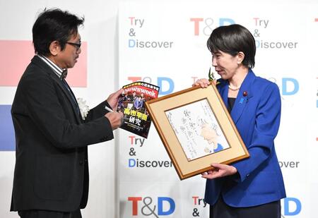 　高市早苗首相（右）にサインを求める選考委員のやくみつる（撮影・開出牧）