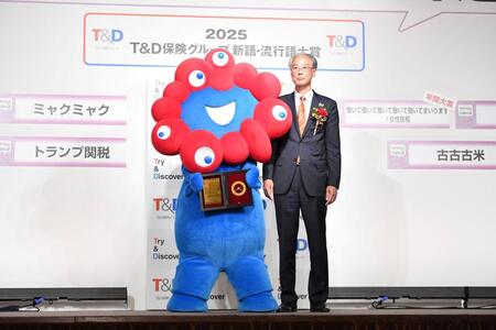 　盾を手にポーズを決める大阪・関西万博公式キャラクターのミャクミャク（左）と日本国際博覧会協会副事務総長の高科淳氏（撮影・開出牧）