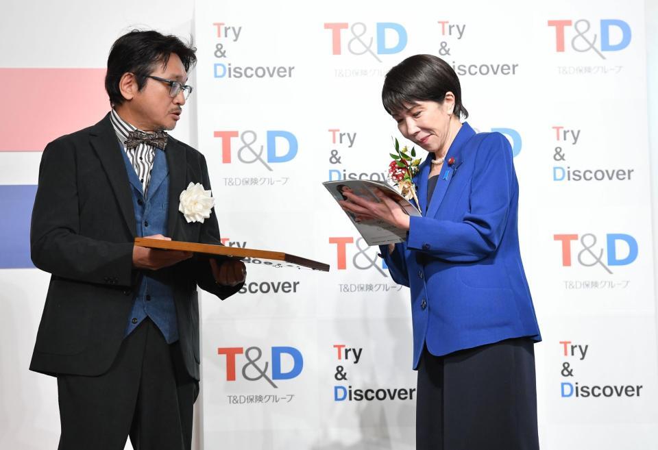 　選考委員のやくみつる（左）にサインのサービスをする高市早苗首相（撮影・開出牧）