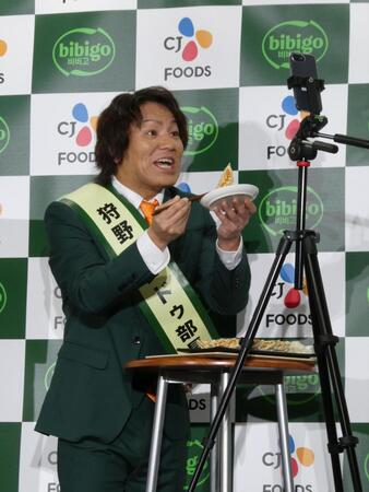 マンドゥを食べる撮影を行う狩野英孝＝都内