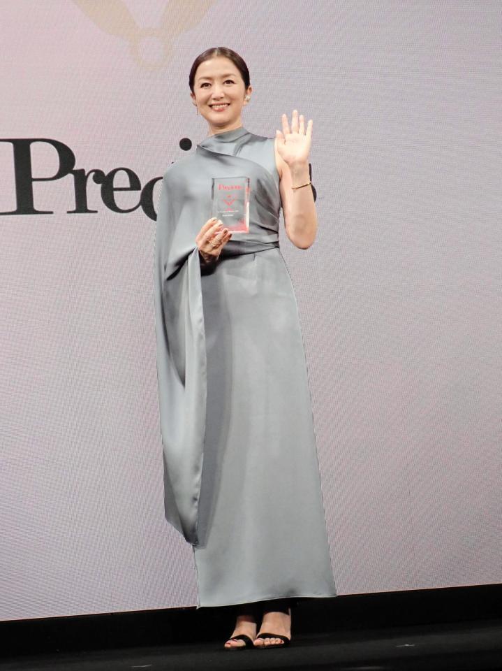 　「時の人」賞のトロフィーを右手に、笑顔で左手を振る鈴木京香