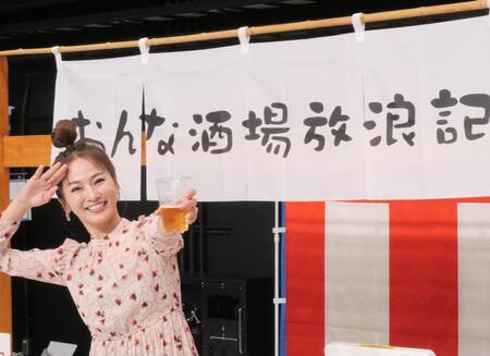 　自身が出演するＢＳ－ＴＢＳ「おんな酒場放浪記］とコラボした屋台の前でビール片手にポーズを取る倉本康子