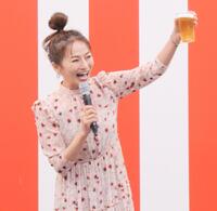 　自身が出演するＢＳ－ＴＢＳ「おんな酒場放浪記］とコラボした屋台の前でビール片手にポーズを取る倉本康子