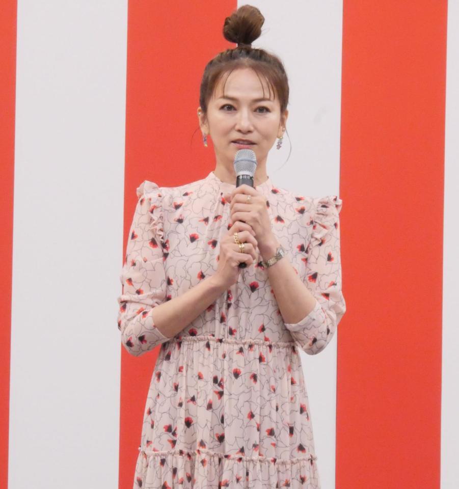 　自身が出演するＢＳ－ＴＢＳ「おんな酒場放浪記］とコラボした屋台の前でビール片手にポーズを取る倉本康子