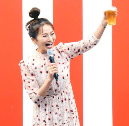 　自身が出演するＢＳ－ＴＢＳ「おんな酒場放浪記］とコラボした屋台の前でビール片手にポーズを取る倉本康子