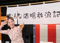 　自身が出演するＢＳ－ＴＢＳ「おんな酒場放浪記］とコラボした屋台の前でビール片手にポーズを取る倉本康子