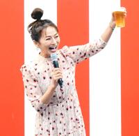　自身が出演するＢＳ－ＴＢＳ「おんな酒場放浪記］とコラボした屋台の前でビール片手にポーズを取る倉本康子