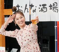 　ビール片手にポーズを取る倉本康子