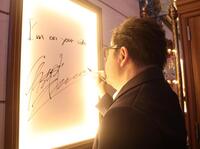 　劇場の壁にメッセージを記入した秋元康氏（撮影・石井剣太郎）