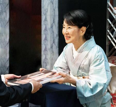　ファンにサイン入りの写真集を手渡す吉永小百合