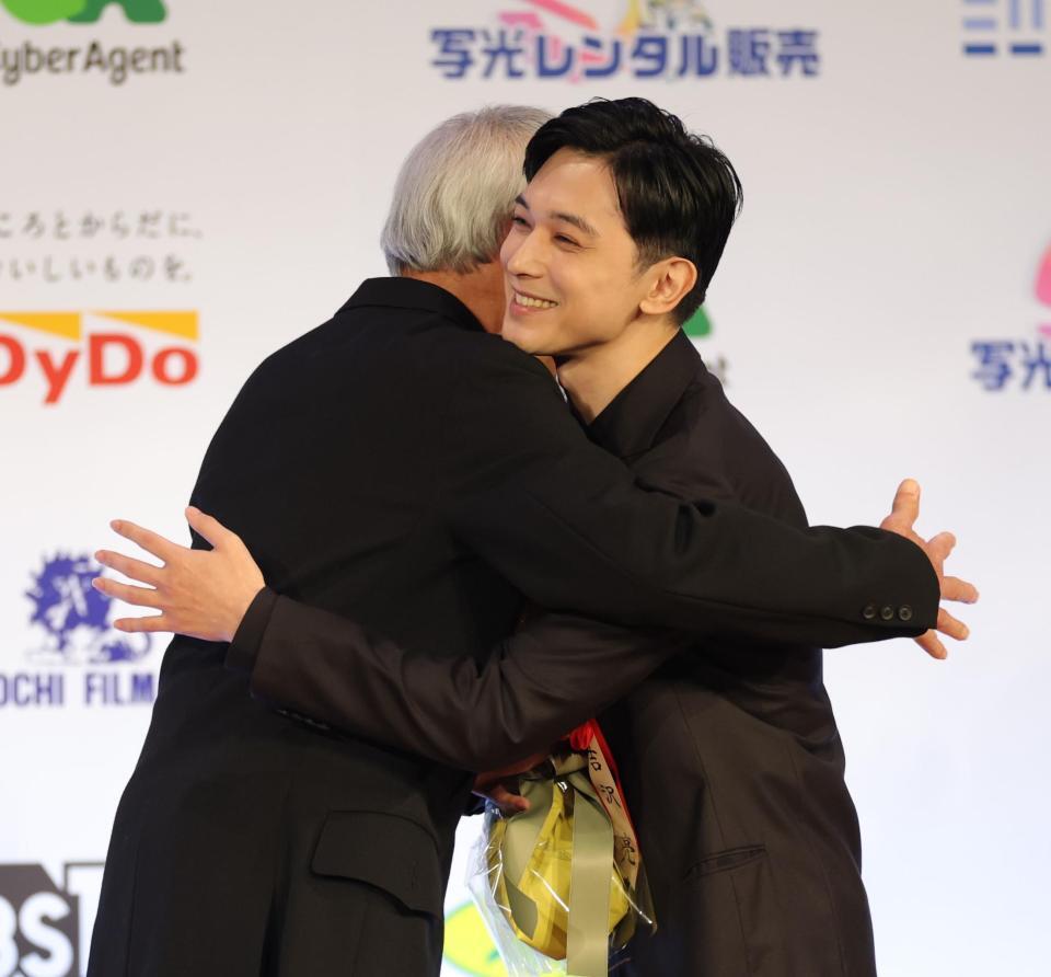 　祝福した田中泯（左）と抱き合う吉沢亮（撮影・西岡正）