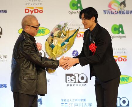 　秋山純監督（左）から花束を受け取る松谷鷹也（撮影・西岡正）