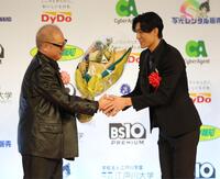 　秋山純監督（左）から花束を受け取る松谷鷹也（撮影・西岡正）