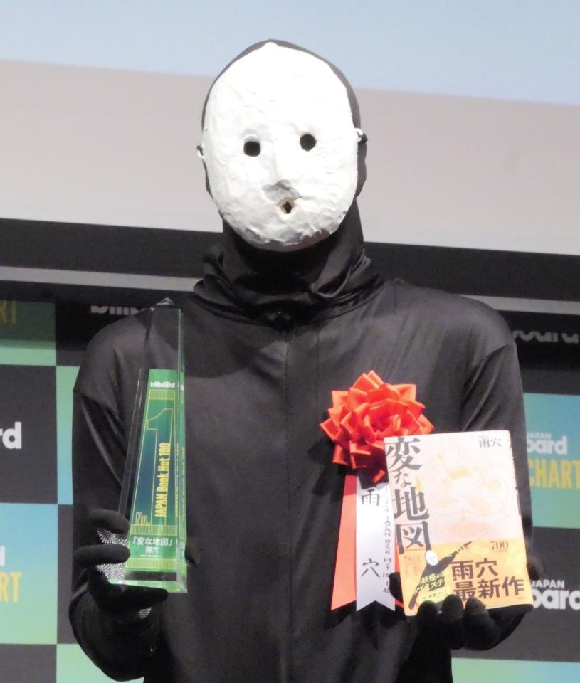 　トロフィーと著書を手に撮影に応じた雨穴