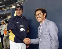 　具志堅用高氏（右）と握手するオリックス・森脇浩司監督＝２０１３年