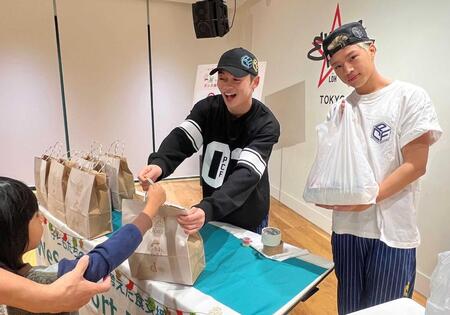 　子供にプレゼントを贈る中西椋雅（左）と半田龍臣