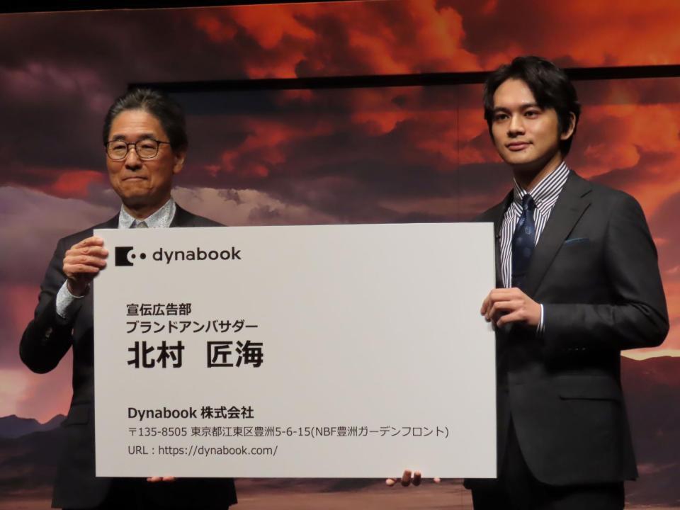 　ブランドアンバサダーの名刺を覚道清文社長（左）から贈呈される北村匠海