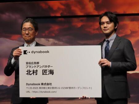 　ブランドアンバサダーの名刺を覚道清文社長（左）から贈呈される北村匠海