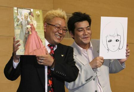 挙式の写真を手に富澤たけし（右）とＷ結婚会見を行ったサンドウィッチマン・伊達みきお（０９年７月）