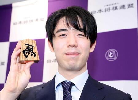 　「左馬（ひだりうま）」の駒を手にほほ笑む藤井聡太六冠（撮影・中田匡峻）