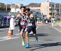 　平塚中継所で、天野啓太（左）からたすきを受け取る日大・山口月暉（撮影・吉澤敬太）