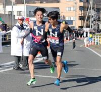 　平塚中継所で、日大・天野啓太（左）から山口月暉へたすきを繫ぐ（撮影・吉澤敬太）