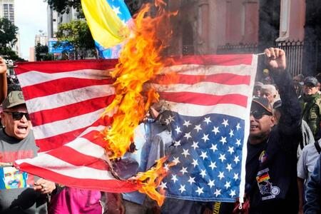 　ベネズエラの首都カラカスで米国旗を燃やす人たち（ＡＰ＝共同）