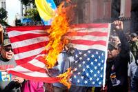 　ベネズエラの首都カラカスで米国旗を燃やす人たち（ＡＰ＝共同）