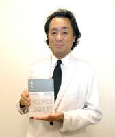 　書籍「美人」を手にする柘植伊佐夫氏