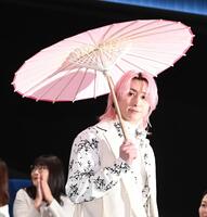 傘をさして登場した佐久間大介（撮影・園田高夫）