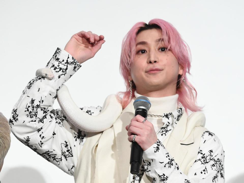 白蛇を腕に巻く佐久間大介（撮影・園田高夫）