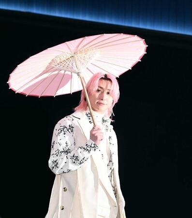 　傘をさして登場する佐久間大介（撮影・園田高夫）