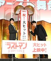 　くす玉から出てきた垂れ幕を指差す福山雅治（左）と大泉洋（撮影・佐藤厚）