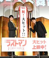 　くす玉から出てきた垂れ幕を指差す福山雅治（左）と大泉洋（撮影・佐藤厚）