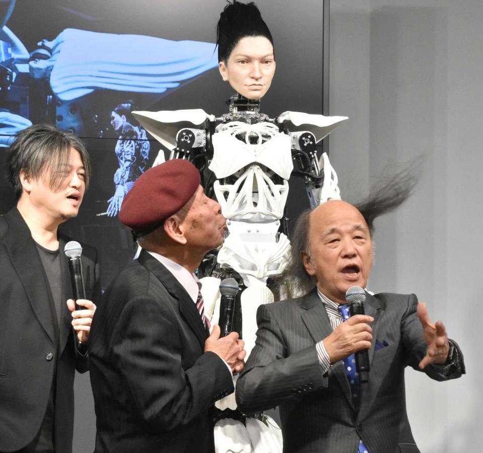 　アンドロイド・マリア（奥）の前で髪を吹き飛ばす海原はるか・かなたの海原かなた（中央）と海原はるか（右）。左は渋谷慶一郎氏